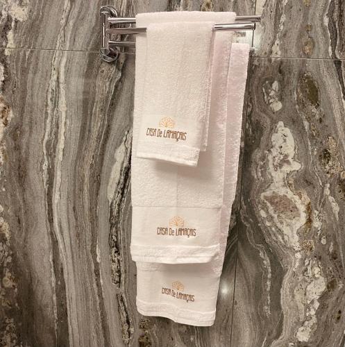 two white towels hanging on a wall in a bathroom at Casa de Lamaçais in Vilela