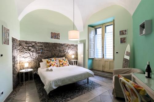 een slaapkamer met een bed en een stenen muur bij Al Palazzetto di Milo in Milo