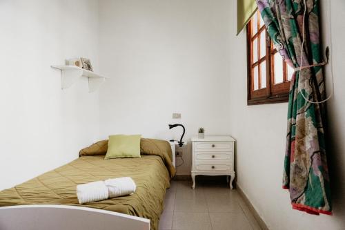 a small bedroom with a bed and a dresser and a window at Casa El Guincho, Garachico in El Guincho