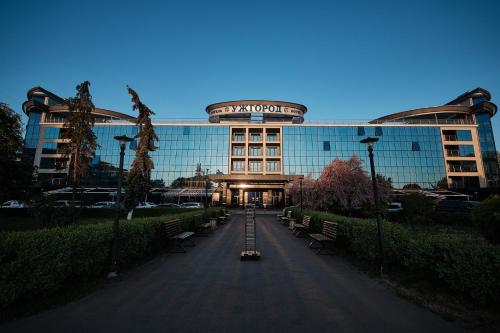 um grande edifício com bancos em frente em Hotel Uzhgorod em Uzhhorod