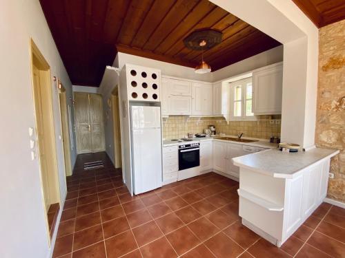 a kitchen with white cabinets and a tile floor at To Petrino in Meyisti