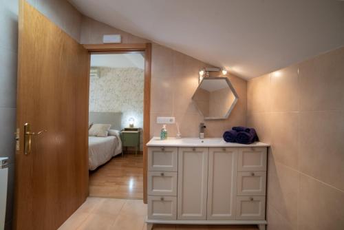 baño con lavabo y habitación con cama en IRIMO, en Tudela
