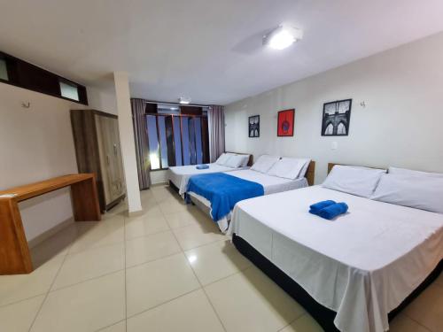 a hotel room with two beds and a television at Ponta Negra Temporada in Natal