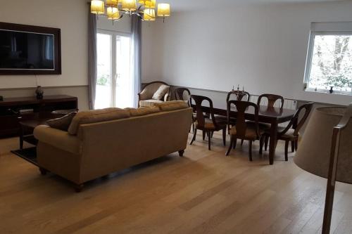 een woonkamer met een bank en een eettafel bij villa frontière suisse Topdestination-Annemasse in Gaillard