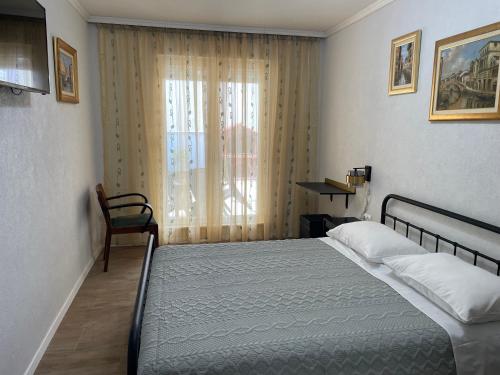 a bedroom with a bed and a chair and a window at Apartments Znjan in Split