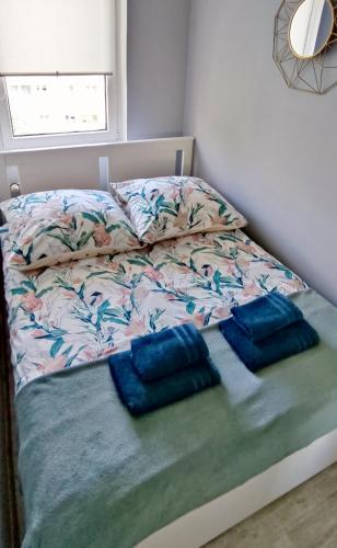 a bed with two blue pillows on top of it at Lovely place-apartament Oświęcim in Oświęcim