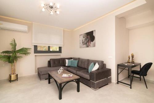 a living room with a couch and a table at Villa Adiola, An Unrivalled Retreat in Kalamaki