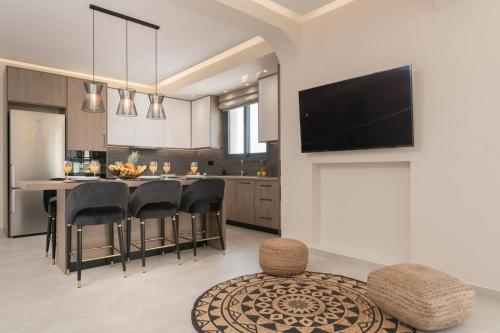 a kitchen with a table and chairs and a tv at Villa Adiola, An Unrivalled Retreat in Kalamaki