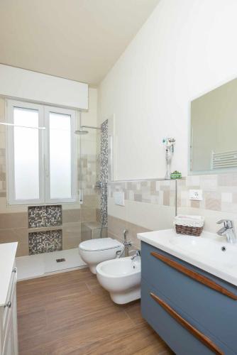 a bathroom with two sinks and a toilet and a tub at Ci Vuole Leggerezza Apartment Free Parking in Bologna