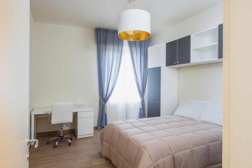 a bedroom with a bed and a desk and a window at Ci Vuole Leggerezza Apartment Free Parking in Bologna