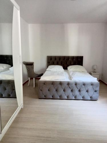 a bedroom with two beds and a chair at Willa Aqua -parking included in the price in Świnoujście
