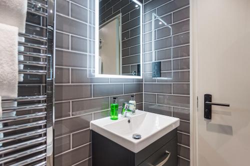 a bathroom with a sink and a mirror at The George Hotel, Amesbury, Wiltshire - The Coaching Inn Group in Amesbury