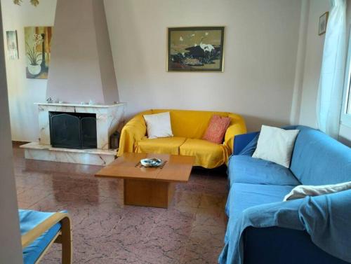 Skhoínos的住宿－Maisonette magnolia，客厅配有黄色的沙发和桌子