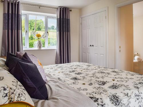 a bedroom with a bed and a window at Bryn Bannon in Cilcain