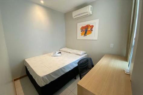 a small room with a bed and a table at HOSPEDE-SE JÁ DUPLEX in Brasilia