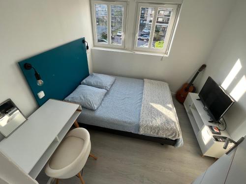 a small bedroom with a bed and a desk at Vivez proche du port de plaisance - 2 chambres - Calme in Le Havre