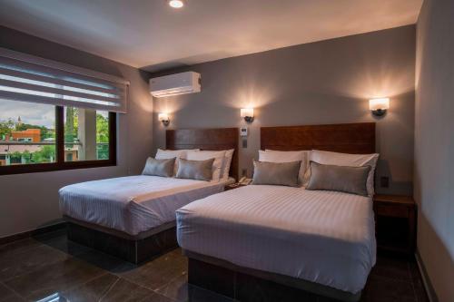 - 2 lits dans une chambre d'hôtel avec fenêtre dans l'établissement Hotel La Querencia, à Río Verde