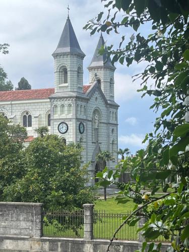 a church with a clock tower on top of it at Hotel Alvaro frente Palacio-Museo Selgas in Cudillero