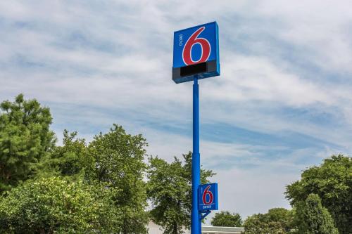 un cartel con el número seis en un poste azul en Motel 6-Goodlettsville, TN - Nashville, en Goodlettsville