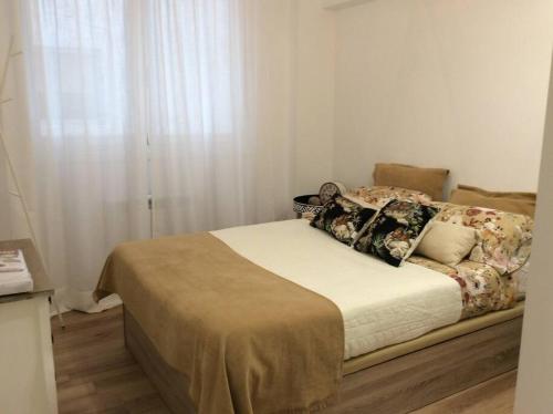 ein Schlafzimmer mit einem Bett mit Kissen und einem Fenster in der Unterkunft HyP - Urban Vigo in Vigo