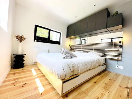 1 dormitorio con 1 cama grande y suelo de madera en La Suite (Ô) Wood & Chic, en Cucq