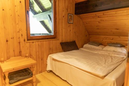 a bedroom with a bed in a wooden cabin at VILA HELENA in Velenje