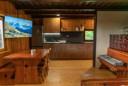 a kitchen with a wooden table and a large screen at VILA HELENA in Velenje