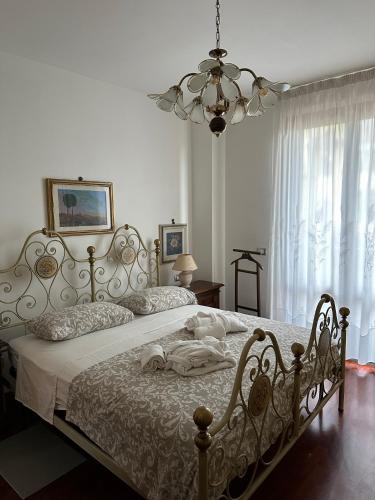 a bedroom with a large white bed with a chandelier at Casa Maria (posto auto gratuito) in San Donnino