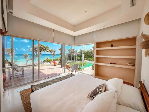 a bedroom with a large bed and a view of the ocean at 15 minutes from Tulum - Siete Gotas in Tulum