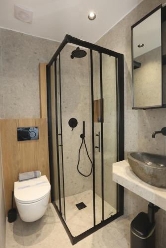 a bathroom with a shower with a toilet and a sink at Cozy By Syros Bnb in Ermoupoli