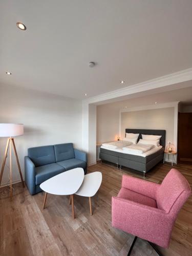 1 dormitorio con cama, sofá y mesa en Hotel Paula Norderney, en Norderney