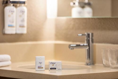 Un lavabo en un baño con dos letreros de precio. en Staybridge Suites Fort Wayne, an IHG Hotel en Fort Wayne