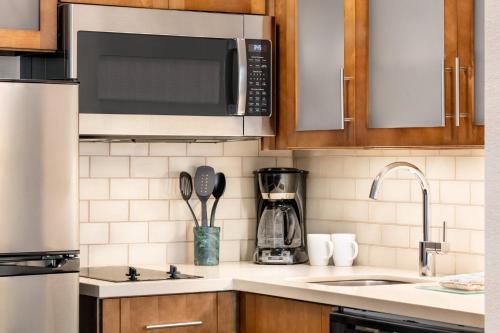 a kitchen with a sink and a microwave at Staybridge Suites Fort Wayne by IHG in Fort Wayne