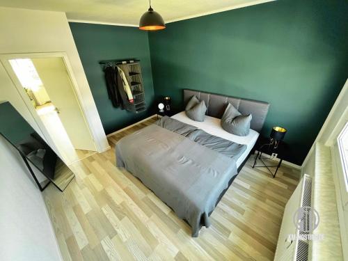 um quarto com uma cama e uma parede verde em KMHosting Luxe Apartment Chemnitz-Zentrum em Chemnitz