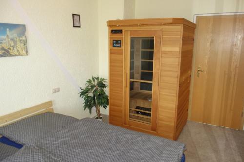 クアオルト・オーバーヴィーゼンタールにあるFerienwohnung Oberwiesenthalのベッドルーム1室(ベッド1台付)、木製キャビネットが備わります。