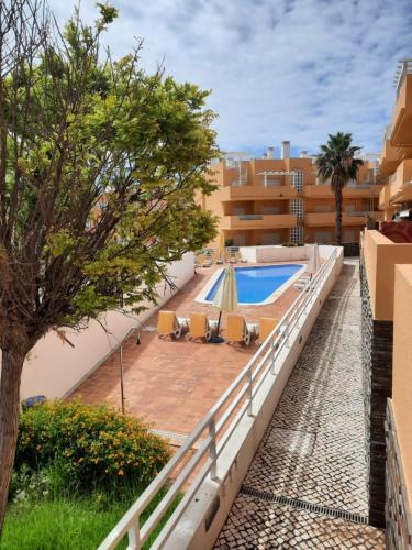 uma vista para a piscina a partir da varanda de um edifício em Sunshine Apartment em Tavira
