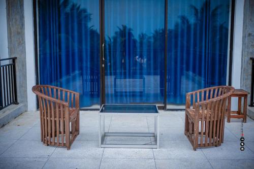 2 chaises et une table devant une fenêtre dans l'établissement Aqua Marine Beach Hotel, à Kalkudah