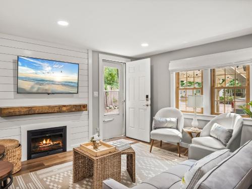 a living room with a fireplace and a tv at Cape Cod Cottage, near Beach, Hot Tub, AC, Dog Friendly in Yarmouth