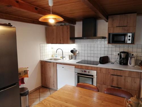 a kitchen with a sink and a stove top oven at Grand gite 14 personnes ,cour ,salle de jeux, proche du village , commerces in Murat