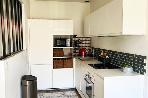 une cuisine avec des armoires blanches et un micro-ondes dans l'établissement Ultra central, air conditionned, very quiet!, à Nice