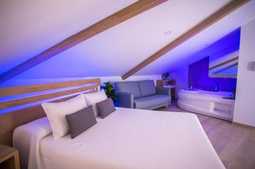 a bedroom with a large white bed and a couch at Apartahotel Énfasis-Group in El Cuervo