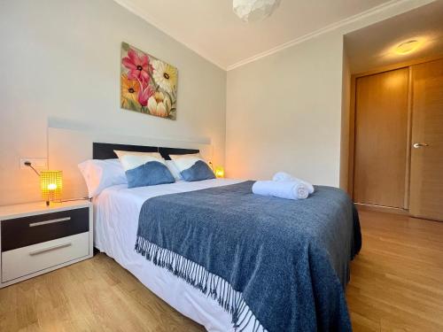- une chambre avec un grand lit et une couverture bleue dans l'établissement Öspede Surf And Montain Malpica de Bergantiños-Costa da Morte, à Malpica