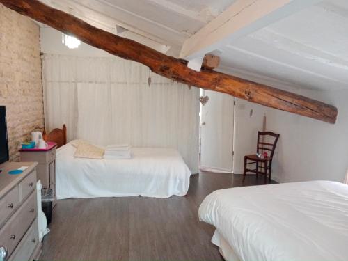 a bedroom with two beds and a television in it at La Cour in Villefagnan