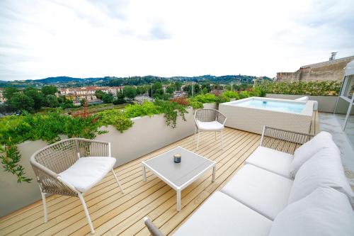 uma varanda com um sofá e cadeiras e uma piscina em The Rooftop em Florença