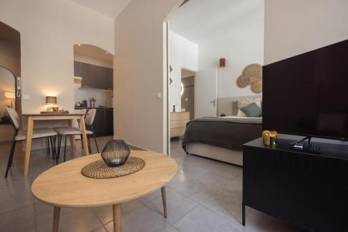 - un salon avec un lit, une table et une télévision dans l'établissement Splendide et idéalement situé proche du palais., à Cannes