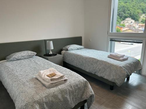 ein Schlafzimmer mit 2 Betten und Handtüchern darauf in der Unterkunft LabPark design apartment in Melano