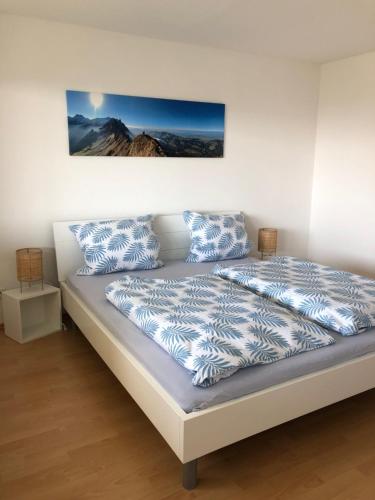 1 cama con almohadas azules y blancas en una habitación en Ferienwohnung Fernsicht, en Markdorf