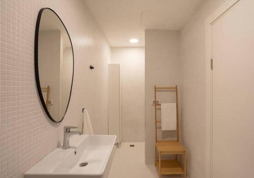 a white bathroom with a sink and a mirror at A Bauhaus Gem - Prime Location in Tel Aviv