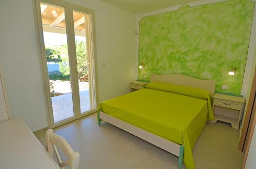 a bedroom with a green bed and a window at B&B Lu Cantoru in Marina di Pescoluse