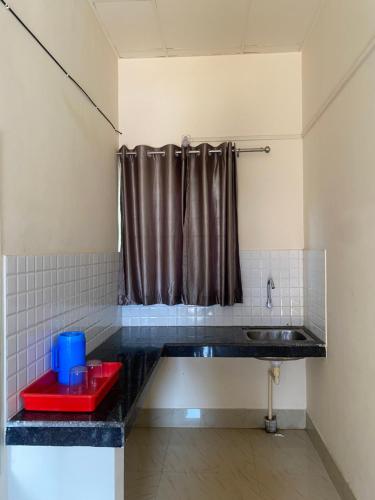 a bathroom with a sink and a shower curtain at Atithya Lodge in Guwahati